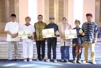 Gubernur Banten Andra Soni saat memberikan hadiah pada anak-anak dalam gelaran akbar Pekan Kebudayaan Daerah yang digelar di Gedung Negara, Kota Serang. (Ist)