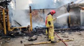 Petugas pemadam kebakaran menyemprotkan air untuk memadamkan sisa-sisa api yang membakar sebuah rumah makan berbentuk saung bambu di kawasan Sudimara Pinang, Kota Tangerang, Doc (Ist/Totalbanten.com)